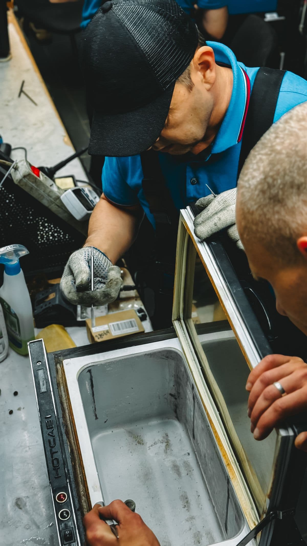 Technicians repairing a refrigerator at an RK Aircon service centre in Chennai